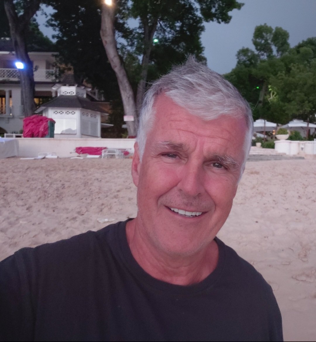 Dominic Pierse pictured from the waist up on a beach in Barbados.